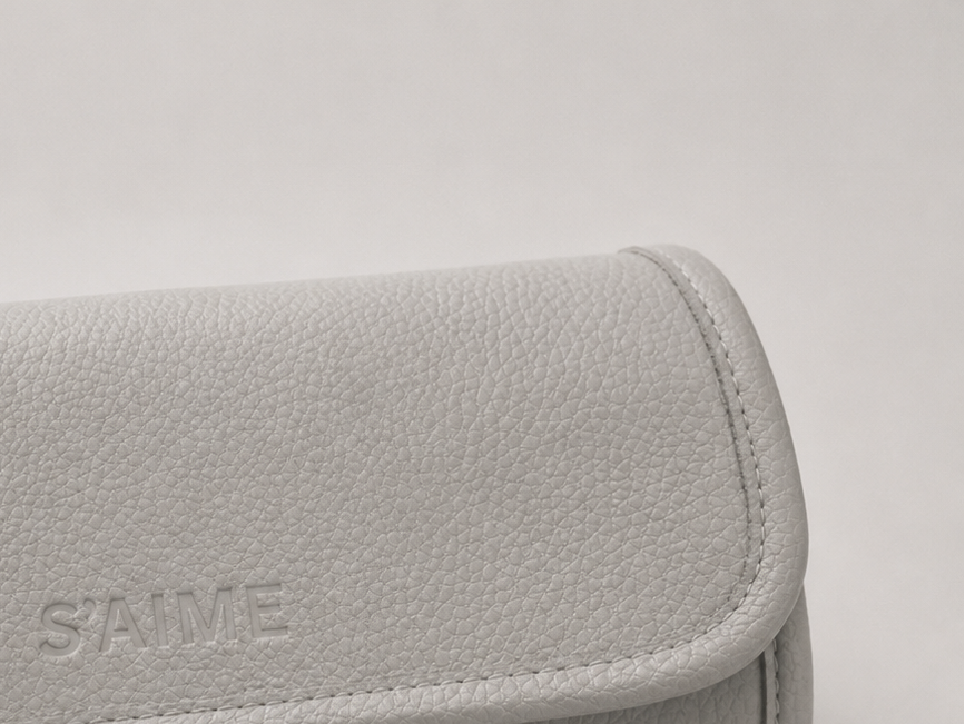 Gray wallet with 'S aime' branding on a light gray background